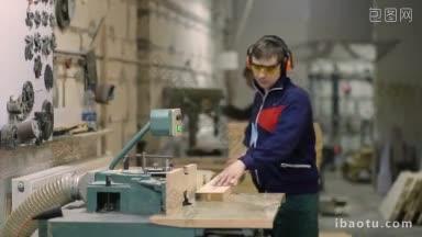 熟练的工匠在车间用圆锯切割木板，木匠戴着防护眼镜和耳套用圆锯工作
